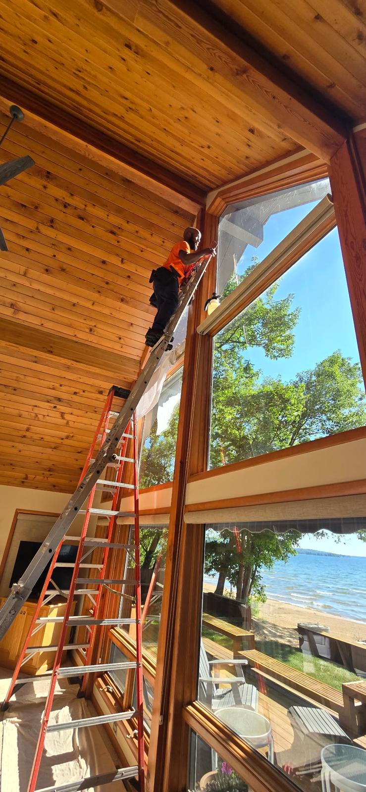 DRE installing architectural window film on a vaulted lakefront atrium